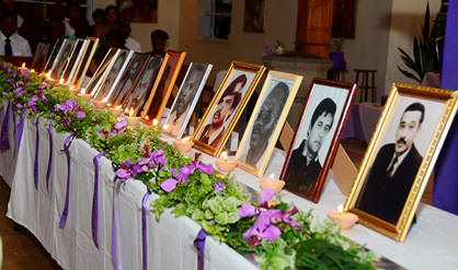 De portretten van de vijftien slachtoffers van de Decembermoorden tijdens de herdenkingsdienst, zondag, in de St. Alphonsiuskerk