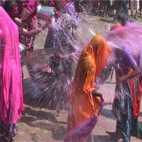Holi-Parva vierders overgieten elkaar met gekleurd water