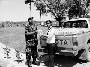 Foto-onderschrift:Jeugdparlementarir Kajal Tahdil overhandigt symbolisch enkele flessen water aan een van de militairen in het district Nickerie die voor het verdere transport van het water zullen zorgdragen.-.
