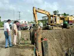 Foto: Districtscommissaris Hardeo Ramadhin en hoofd van de Civiel Technische Afdeling van het commissariaat, Soebhas Jairam, krijgen uitleg van projectleider Gert Roza over de werkzaamheden ter vervanging van de duikers bij de Nursery-sluis.-.