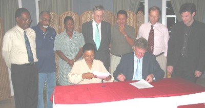 Aan de tafel TCT-directeur Marlene Harris, voorzitter van de Surinaamse luchtvaartcommissie, en Erik Bussink, haar Nederlandse counterpart, kort na de ondertekening van het eindverslag van het luchtvaartoverleg.-.